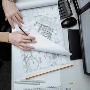 High-angle view of an architect reviewing construction drawings on a desk in an office.